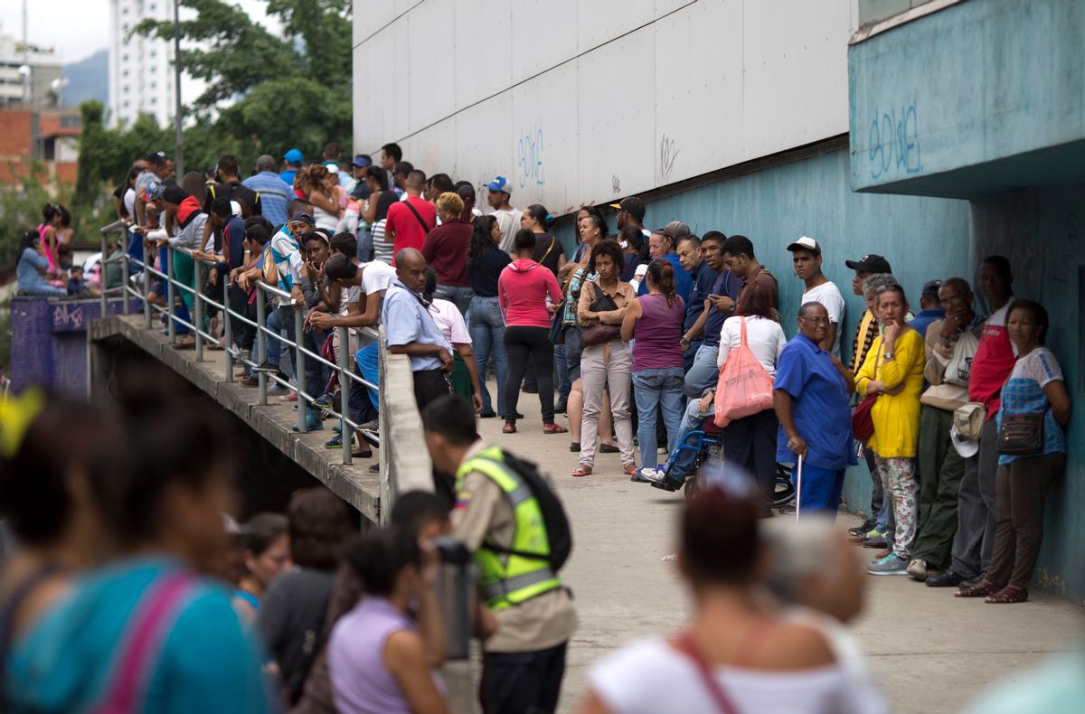 In this Nov. 18, 2016 photo, people wait outside a supermarket to buy government subsided food in Caracas, Venezuela. As domestic production dries up in Venezuela, the state has given itself the role of importing nearly all the country's food.  (AP)