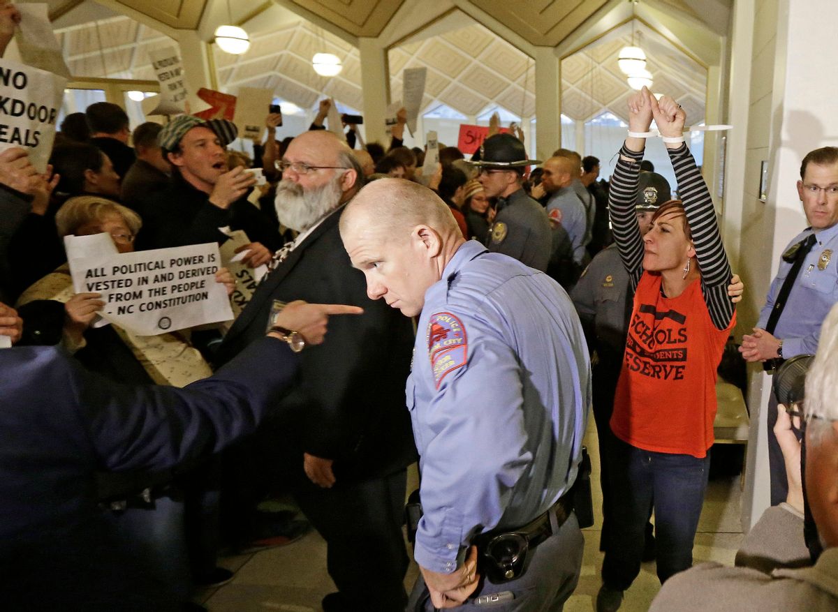 A protestor, right, is handcuffed and removed from the House gallery as demonstrators interrupted a special session at the North Carolina Legislature in Raleigh, N.C., Thursday, Dec. 15, 2016. North Carolina Gov.-elect Roy Cooper said Thursday he's ready to fight in court against Republican legislation moving through the surprise General Assembly session that would undercut his powers as he takes office next month. (AP Photo/Gerry Broome) (AP)