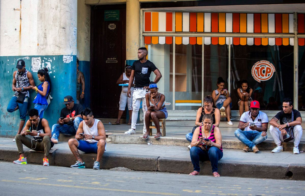In this Jan. 6, 2017 photo, people use a public wifi hotspot in Havana, Cuba. Home internet came to Cuba in December 2016, in a limited pilot program that’s part of the most dramatic change in daily life here since the declaration of detente with the United States on Dec. 17, 2014. (AP Photo/Desmond Boylan) (AP)