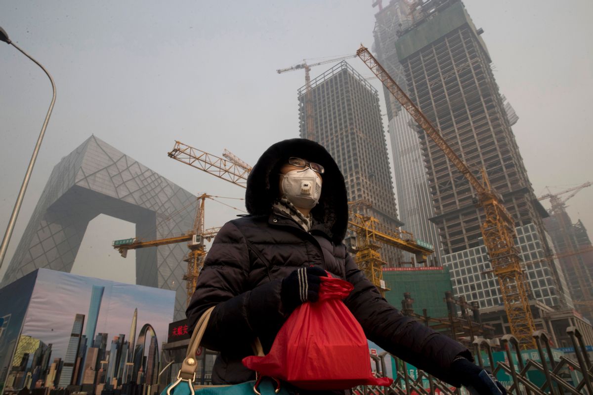 A woman wears a mask as she walks past a construction site as smog continues to choke Beijing on Friday, Jan. 6, 2017. The official Xinhua News Agency reported this week that the environmental ministry had given out punishments after finding that more than 500 construction sites and enterprises, including metallurgy, agricultural chemical and steel plants, and 10,000 vehicles had breached pollution response plans. (AP Photo/Ng Han Guan) (AP)