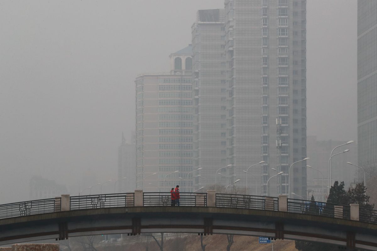 Chinese men wearing masks to filter the pollution walk on a bridge near building shrouded by fog and pollution in Beijing, Thursday, Jan. 5, 2017. China has long faced some of the worst air pollution in the world, blamed on its reliance of coal for energy and factory production, as well as a surplus of older, less efficient cars on its roads. Inadequate controls on industry and lax enforcement of standards have worsened the pollution problem. (AP Photo/Andy Wong) (AP Photo/Andy Wong)