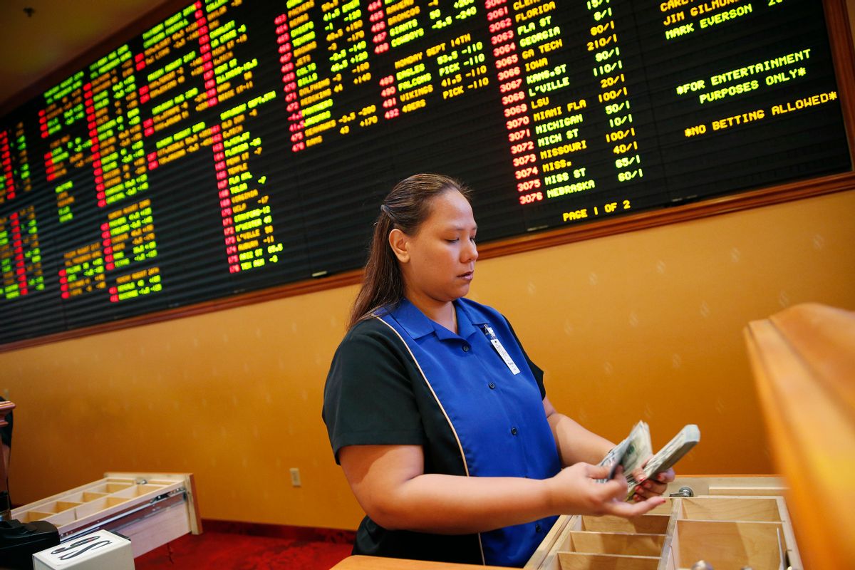 FILE - In this Aug. 20, 2015, file photo, Therese Duenas counts money as she takes bets in the sports book at the South Point hotel and casino in Las Vegas. On the board behind here are odds on NFL football and other bets. Once upon a time, the thought of gambling on a pro football game brought gasps of indignation from the NFL offices. And swift action if it was a player who actually placed a bet. The Oakland Raiders’ new stadium could literally be walking distance from a few of the city’s dozens of sports books. (AP Photo/John Locher, File) (AP)