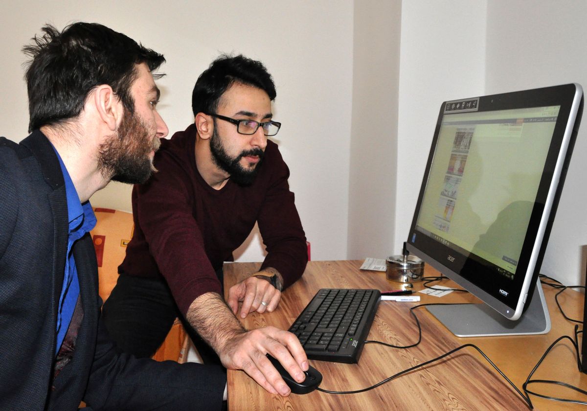 In this Jan. 19, 2017 photo 28-year-old Talal Mando, left, a refugee from Homs, works with writer Mohanad Al-Naheel on his website arabalmanya.com in Berlin, Germany. The website with information and news for recently arrived migrants to Germany has hit one million visitors.(AP Photo/Jona Kallgren) (AP)