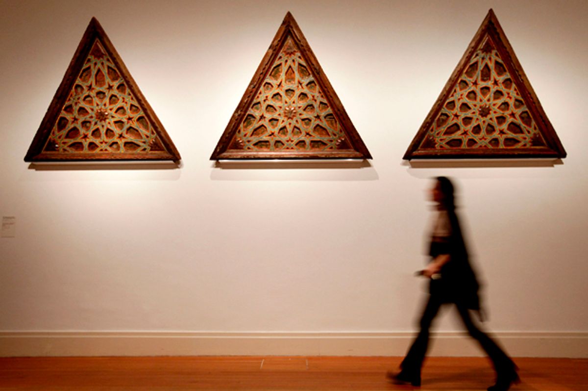  A woman walks past wooden, triangular ceiling panels from 15th century Muslim Spain   (Getty/Sean Gallup)