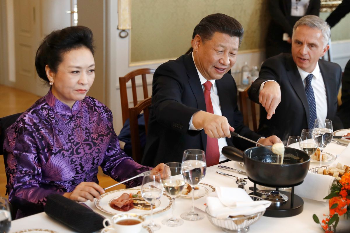 China's President Xi Jinping, center, Xi's wife Peng Liyuan, left, and Swiss Foreign Minister Didier Burkhalter eat Swiss cheese fondue during lunch during Xi's two days state visit to Switzerland in Bern, Switzerland, Monday, Jan. 16, 2017.  (Peter Klaunzer/Pool Photo via AP) (AP)