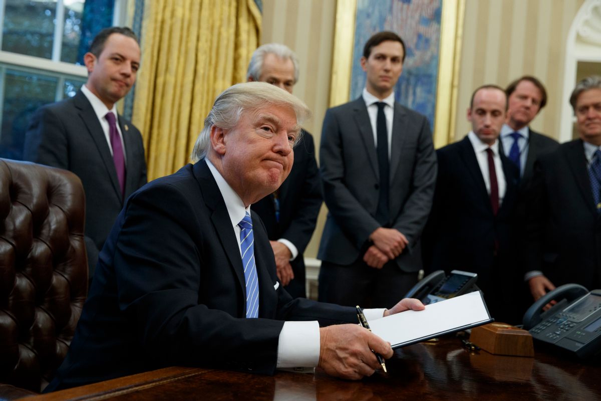 President Donald Trump looks up after signing the final of three executive orders, Monday, Jan. 23, 2017, in the Oval Office of the White House in Washington. (AP Photo/Evan Vucci) (AP/Evan Vucci)