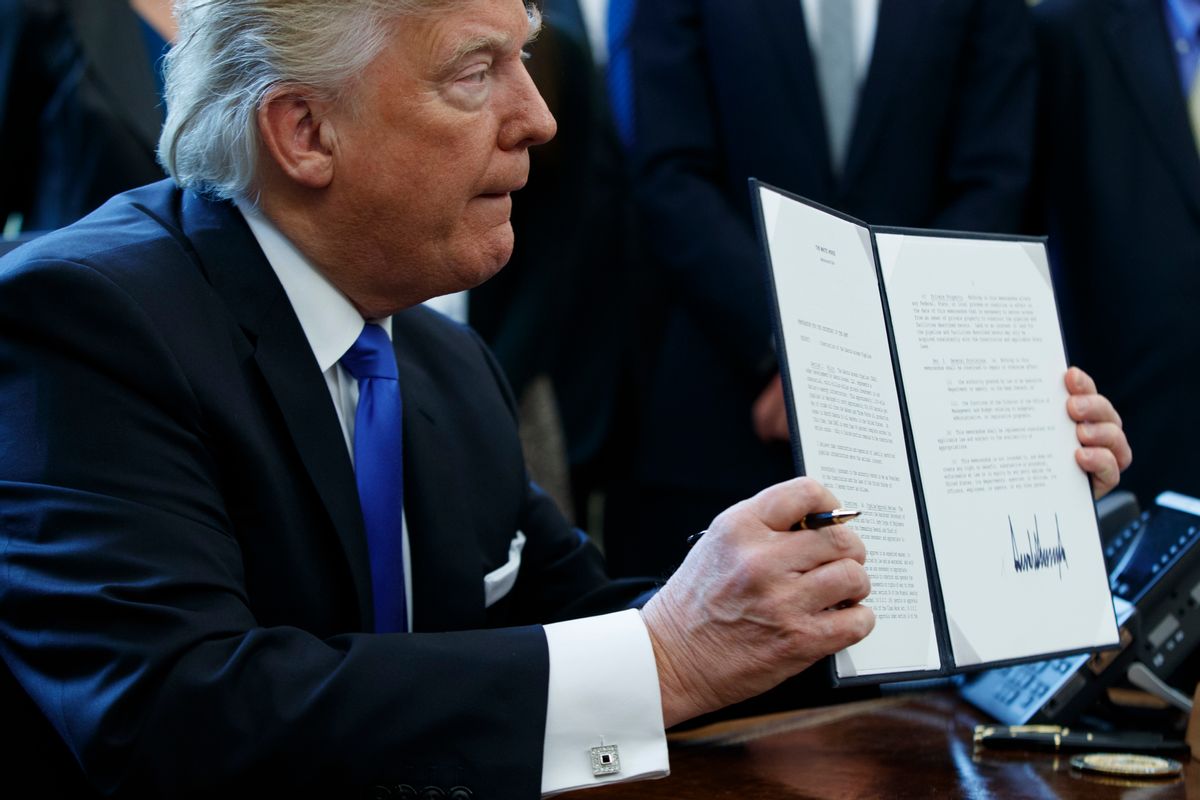 President Donald Trump shows off his signature on an executive order about the Dakota Access pipeline, Tuesday, Jan. 24, 2017, in the Oval Office of the White House in Washington. (AP Photo/Evan Vucci) (AP)