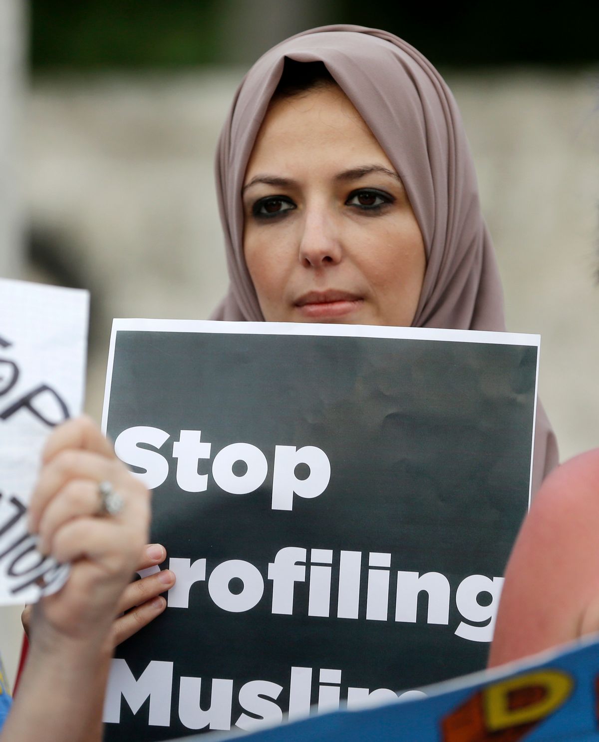 FILE - In this Jan. 22, 2017 file photo, protester Sanaa Alhagri hold a sign during a rally against President Donald Trump's executive order on Muslim immigration, in downtown Miami.  Many citizens of Muslim-majority countries affected by President Donald Trump’s curbs on travel to the United States say they were hardly surprised the restrictions rank among his first orders of business. (AP Photo/Alan Diaz) (AP)