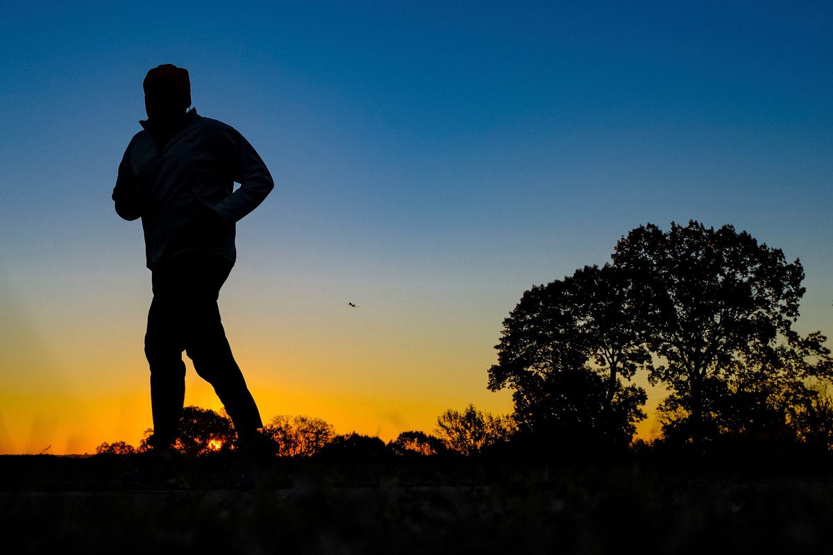 FILE - In this Tuesday, Nov. 22, 2016 file photo, a runner is silhouetted against the sunrise on his early morning workout near Arlington National Cemetery in Arlington, Va., across the Potomac River from the nation's capital. Research released on Monday, Jan. 9, 2017 suggests that people who pack their workouts into one or two days a week lower their risk of dying as much as those who exercise more often, as long as they get enough of it. (AP Photo/J. David Ake) (AP)