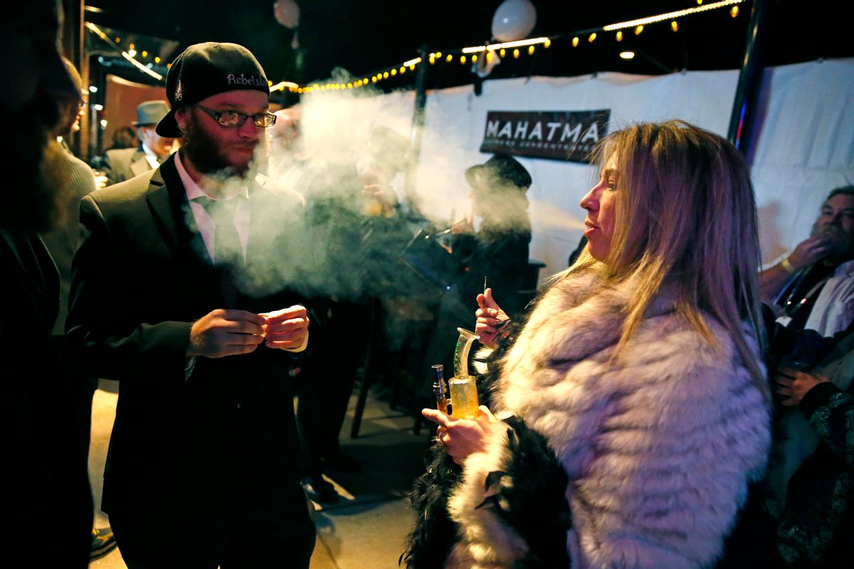 FILE - In this Dec. 31, 2013 file photo, partygoers smoke marijuana during a Prohibition-era themed New Year's Eve invite-only party celebrating the start of retail pot sales, at a bar in Denver. Colorado is on the brink of becoming the first state with licensed pot clubs. Denver officials are working on regulations to open a one-year pilot of bring-your-own marijuana clubs. (AP Photo/Brennan Linsley, File) (AP)