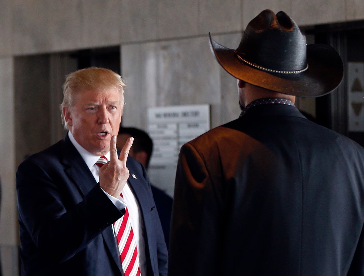 FILE - In this Aug. 16, 2016 file photo, then-Republican presidential candidate Donald Trump gestures as he talks with Milwaukee County Sheriff David Clarke, left, during a campaign stop at Milwaukee County War Memorial Center in Milwaukee. Clarke has risen to the national political spotlight with a brash, unapologetic personality reminiscent of President Donald Trump. But while some Republicans swoon over his prospects for higher office, the tough-talking, cowboy-hat wearing lawman remains one of the most polarizing figures in Wisconsin politics. (AP Photo/Gerald Herbert, File) (AP)