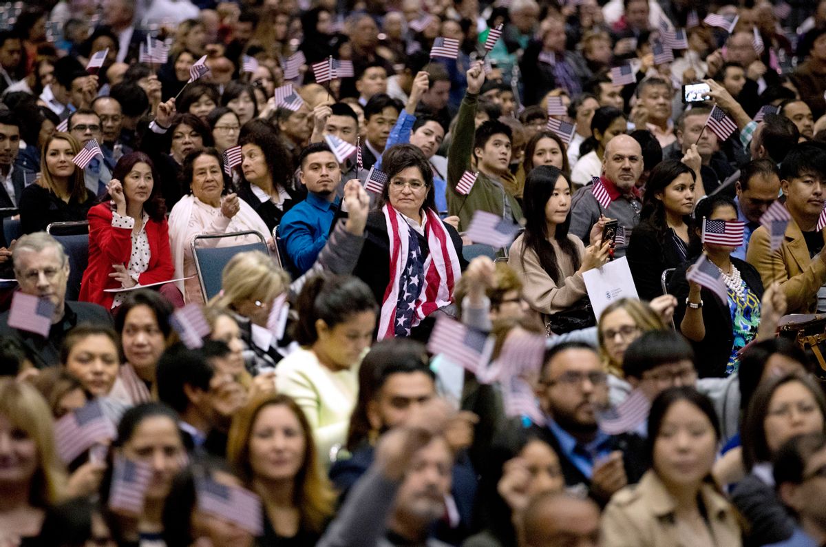 People wave U.S. flags during a naturalization ceremony at the Los Angeles Convention Center, Wednesday, Feb. 15, 2017, in Los Angeles. About 3,000 people took the oath in the morning and more than 3,500 others were expected during an afternoon ceremony, according to U.S. Citizenship and Immigration Services officials. (AP Photo/Jae C. Hong) (AP)