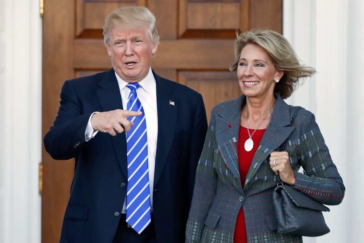 FILE – In this Nov. 19, 2016 file photo, President-elect Donald Trump, left, and Betsy DeVos, right, pose for photographs at Trump National Golf Club Bedminster's clubhouse in Bedminster, N.J. Republican Ohio Gov. John Kasich wrote a Jan. 24, 2017, letter urging confirmation of DeVos, Trump's education secretary nominee, without mentioning the significant unpaid fine owed to Ohio by a now-defunct political action committee she controlled. () (AP Photo/Carolyn Kaster, File)