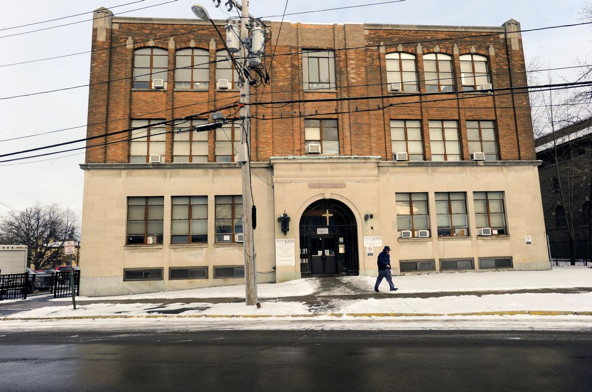 In this Jan. 31, 2017 photo, a pedestrian passes the Mohawk Valley Resource Center for Refugees building in Utica, N.Y. Utica has been a refugee "oasis" for decades. Vietnamese, Bosnians, Somalians and Burmese have each found shelter in the city that has benefited from the infusion of house-proud residents who work in hospitals, factories and their own businesses. But now President Donald Trump's executive order crimping the flow of refugees has sent a shudder through the city in upstate New York. (AP Photo/Hans Pennink) (AP)