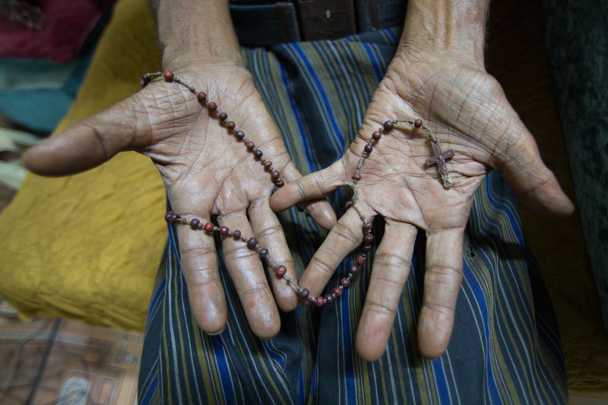 A member of the last remaining originally Christian family in Aden holds a rosary in his hands. Their priest was Father Tom, who was kidnapped last year and is still being held by ISIS. (Maria De La Guardia/Narratively)