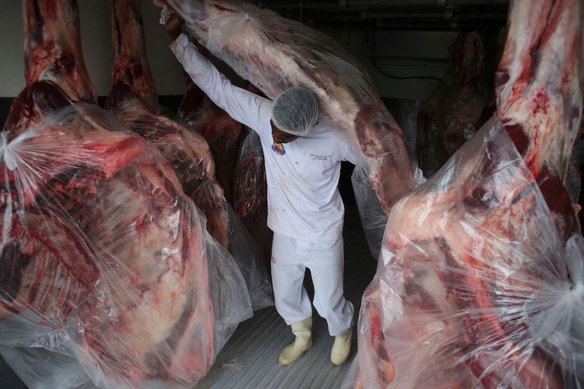 A man delivers sides of beaf to meat to a butcher shop in Brasilia, Brazil, Monday, March 20, 2017. The European Union's spokesman in Brazil says the union is temporarily halting some imports of Brazilian meat amid an investigation into a massive scheme of meat adulteration, which involved some of the country's largest producers. (AP Photo/Eraldo Peres) (AP)