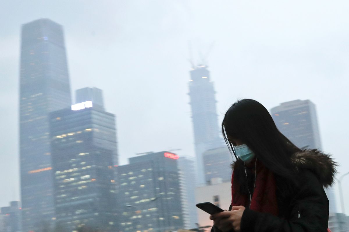 In this Feb. 21, 2017 photo, a woman wearing a mask walks to a subway station during the evening rush hour in Beijing. Yet the city’s average reading of the tiny particulate matter PM2.5 - considered a good gauge of air pollution - is still seven times what the World Health Organization considers safe. A group of Chinese lawyers is suing the governments of Beijing and its surrounding areas for not doing enough to get rid of the smog. (AP Photo/Andy Wong) (AP)
