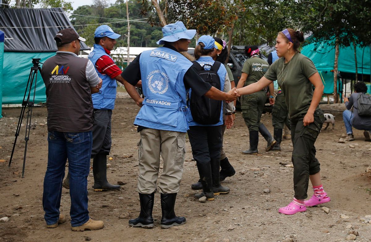 A United Nation observer shakes hands with a rebel of Revolutionary Armed Forces of Colombia, FARC, before a meeting in La Carmelita near Puerto Asis in Colombia's southwestern state of Putumayo,Wednesday, March 1, 2017. Thousands of leftist rebels are taking an important step in Colombia’s peace process by providing to UN observers an inventory of the weaponry they will soon surrender. (AP Photo/Fernando Vergara) (AP)