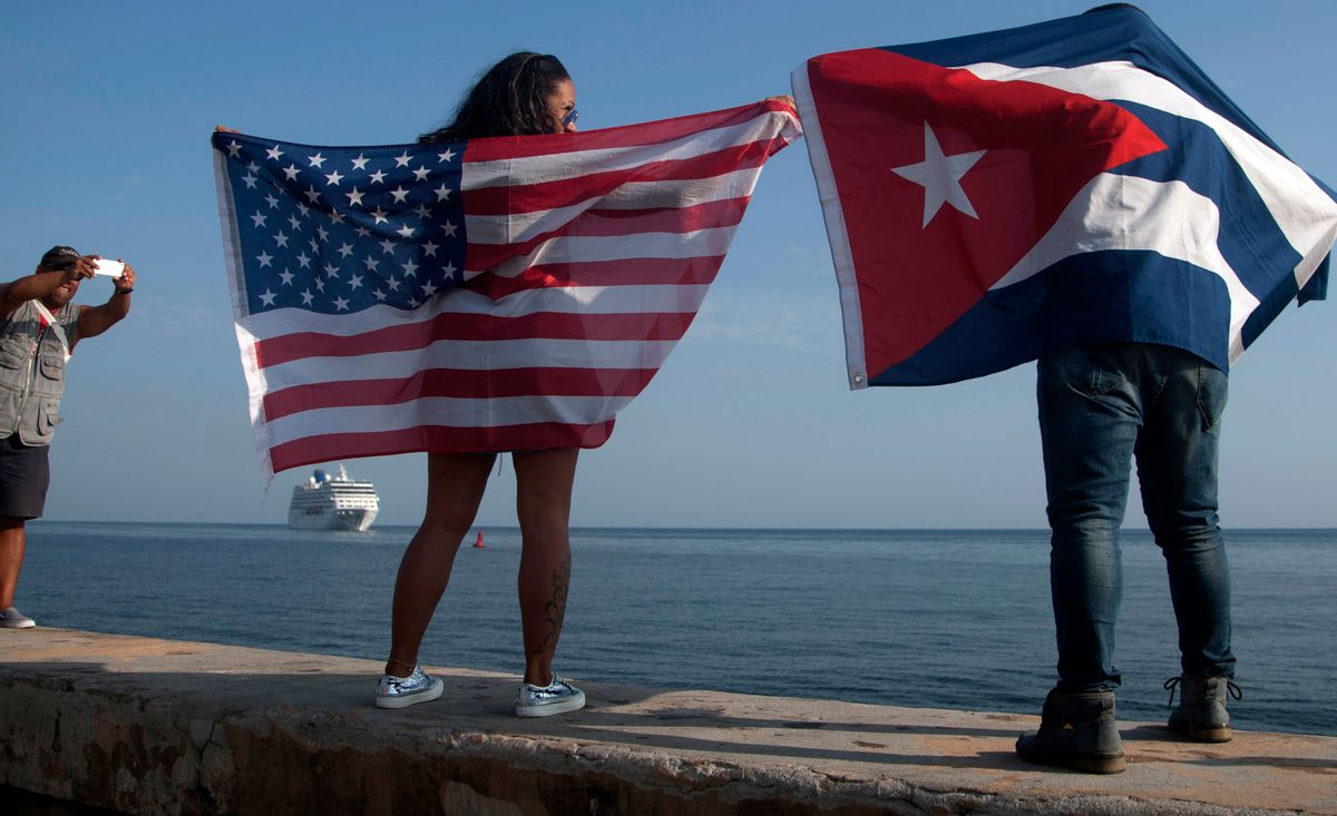 In this May 2, 2016 file photo, Yaney Cajigal, left, holds out a Stars and Stripes, and Dalwin Valdes holds a Cuban national flag, as they watch the arrival of Carnival's Adonia cruise ship from Miami, in Havana, Cuba, the first step toward a future in which thousands of ships a year could cross the Florida Straits, long closed to most U.S.-Cuba traffic. A rare 2016 poll of Cuban public opinion has found that most Cubans approve of normal relations with the United States and large majorities want more tourism and private business ownership. (AP Photo/Fernando Medina, File) (AP)