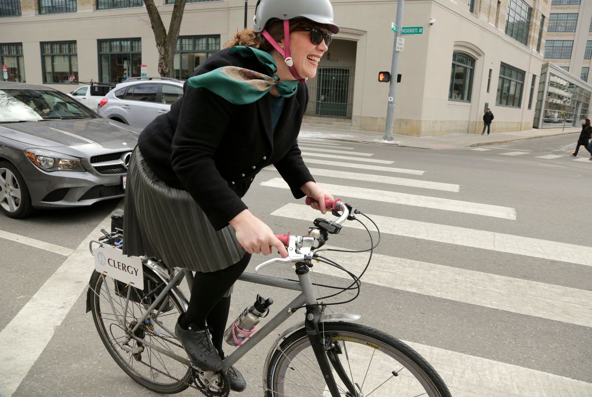 In this Tuesday, March 21, 2017 photo, the Rev. Laura Everett, executive director of the Massachusetts Council of Churches, rides her bike to a meeting of clergy, in Cambridge, Mass. Everett says commuting by bike after her car died has connected her to the city, its neighborhoods and residents. Everett has turned her experiences and the connections she’s drawn between biking and spirituality into a new book, “Holy Spokes: The Search for Urban Spirituality on Two Wheels.” (AP Photo/Steven Senne) (AP)