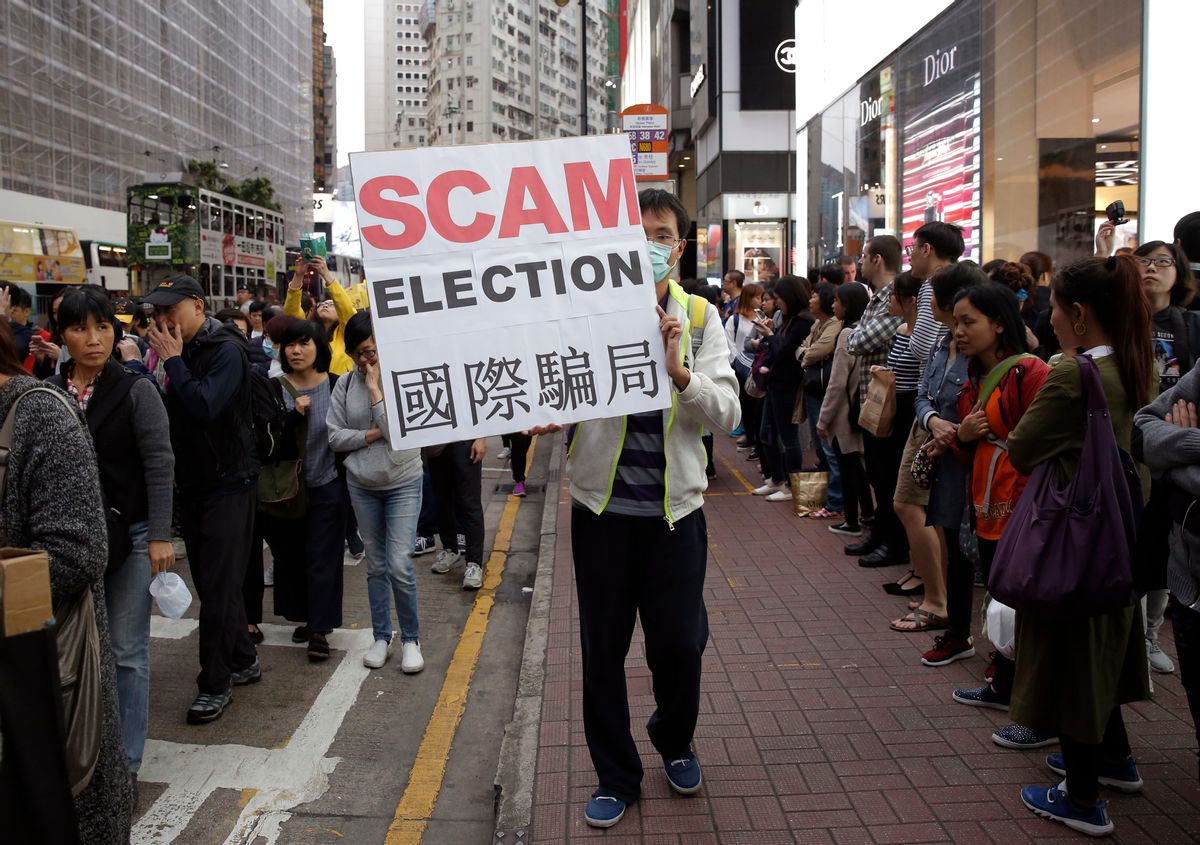 A pro-democracy protester displays a placard during a demonstration in Hong Kong to demand genuine universal suffrage, Saturday, March 25, 2017. Hong Kong is poised to choose a new leader on Sunday when members of a committee dominated by elites favored by Beijing cast their ballots in the first such vote since 2014's huge pro-democracy protests. (AP Photo/Kin Cheung) (AP Photo/Kin Cheung)
