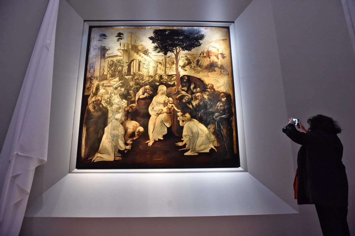 A visitor takes pictures of Leonardo da Vinci’s "Adoration of the Three Wise Men", returned to the public of the Uffizi museum after 6 years of study and restoration, in Florence, Italy, Monday, March 27, 2017. Painted in 1481, it is one of the most important works of the early Leonardo. (Maurizio Degl' Innocenti/ANSA via AP) (AP)
