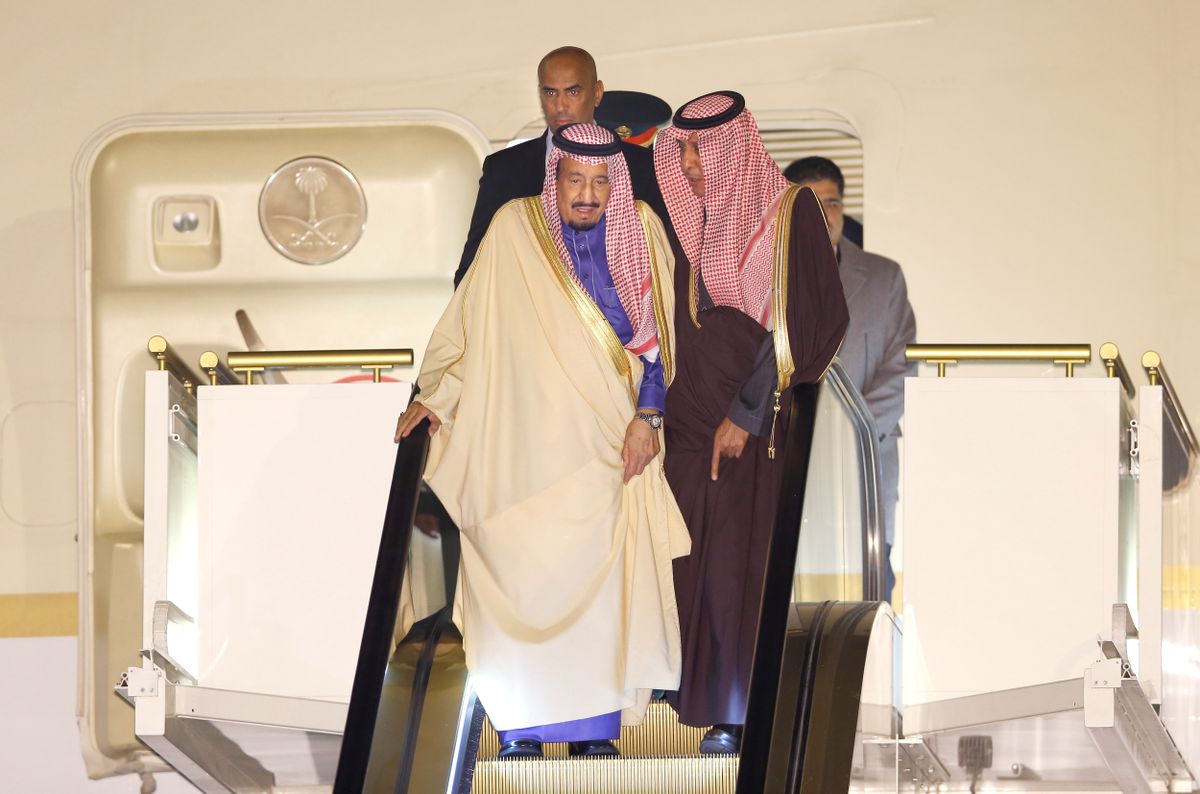 Saudi King Salman, left, rides on a special escalator to disembark from his plane upon his arrival at Haneda International Airport in Tokyo, Sunday, March 12, 2017. (AP Photo/Shizuo Kambayashi)