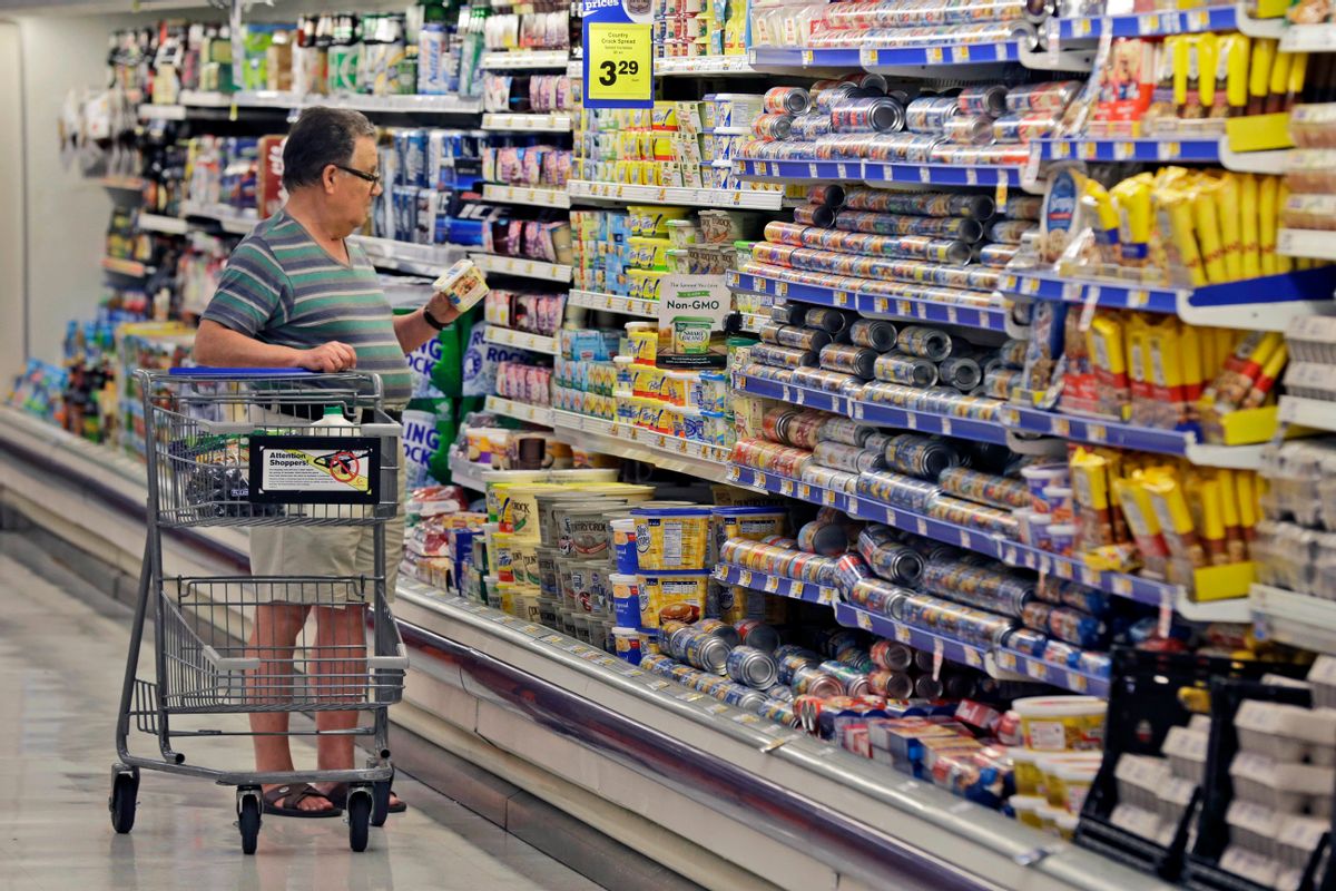FILE - In this June 17, 2014, file photo, a shopper looks at an item in the dairy section of a Kroger grocery store in Richardson, Texas. (AP Photo/LM Otero, File)