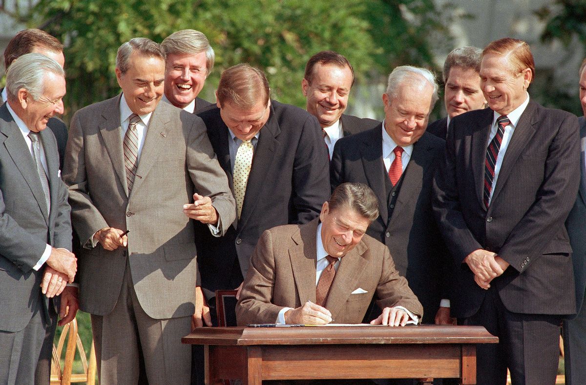 FILE - In this Oct. 22, 1986, file photo, lawmakers watch closely as President Ronald Reagan signs into law a landmark tax overhaul on the South Lawn of the White House in Washington. From left, are: Senate Majority Leader Bob Dole of Kansas, Rep. Raymond McGrath, R-N.Y.; Rep. Dan Rostenkowski, D-Ill., Rep. Frank Guerini, D-N.J.; Sen. Russell Long, D-La.; Rep. William Coyne, D-Pa., and Rep. John Duncan, R-Tenn. The fundamentals of tax overhaul were strong some 30 years ago. Reagan, pushed the landmark 1986 measure. Powerful and experienced congressional leaders shepherded the legislation with bipartisan support. Key players had established, trusting relationships. The situation facing President Donald Trump features none of those advantages. (AP Photo/Bob Daugherty, File) (AP)