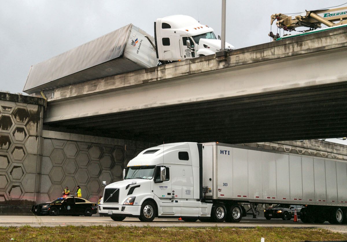 A tractor trailer dangles off the Congress Avenue overpass over I-95 early Wednesday, April 12, 2017, in West Palm Beach, Fla. (Lannis Waters/Palm Beach Post via AP) (AP)