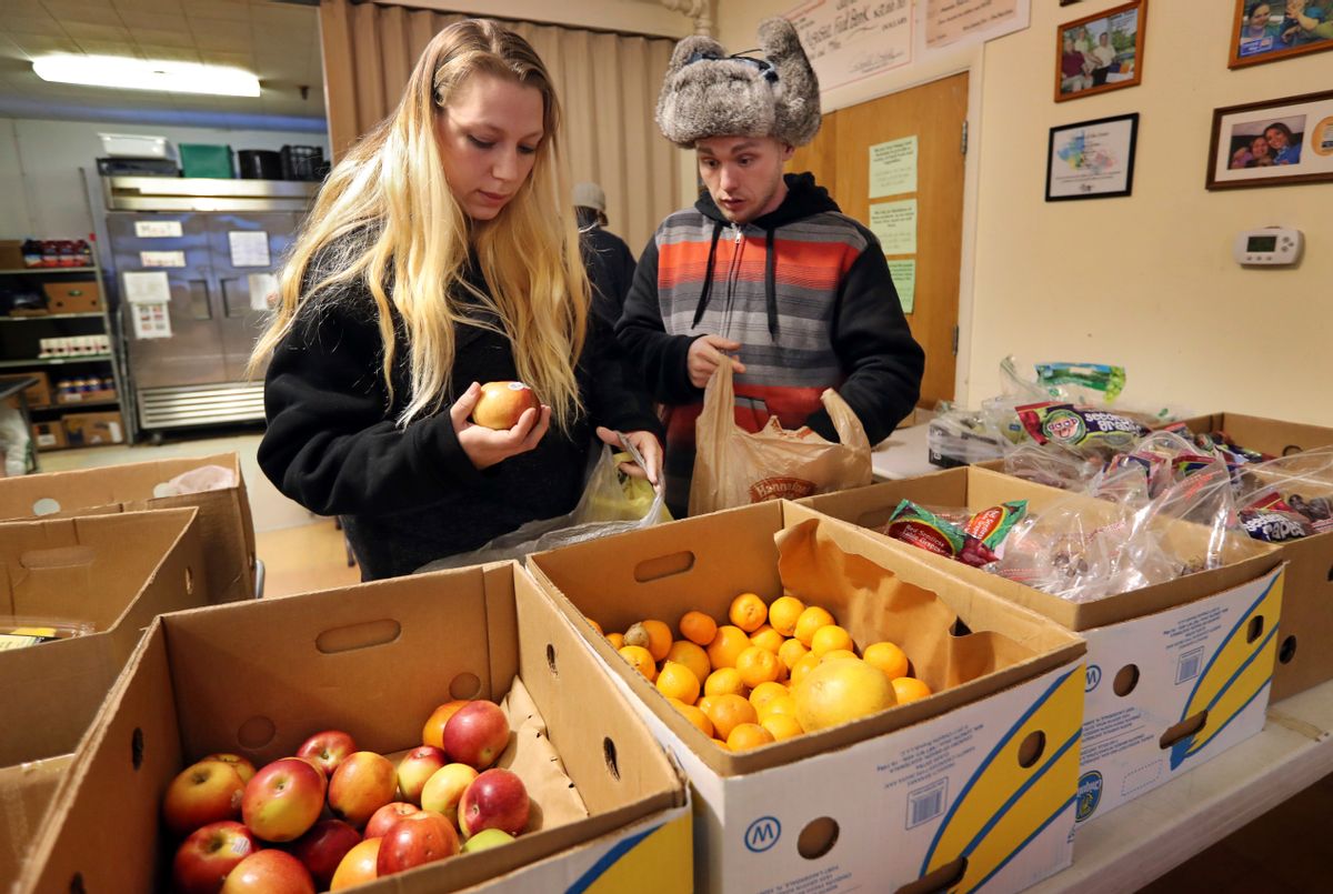 In this Monday, March 27, 2017 photo Sunny Larson, left, and Zak McCutcheon pick produce while gathering provisions to take home at the Augusta Food Bank in Augusta, Maine. Republican Gov. Paul LePage says his call to ban the use of food stamps for soda and candy is backed by science and a desire to reduce obesity and diabetes in the nation's oldest state. (AP Photo/Robert F. Bukaty) (AP)