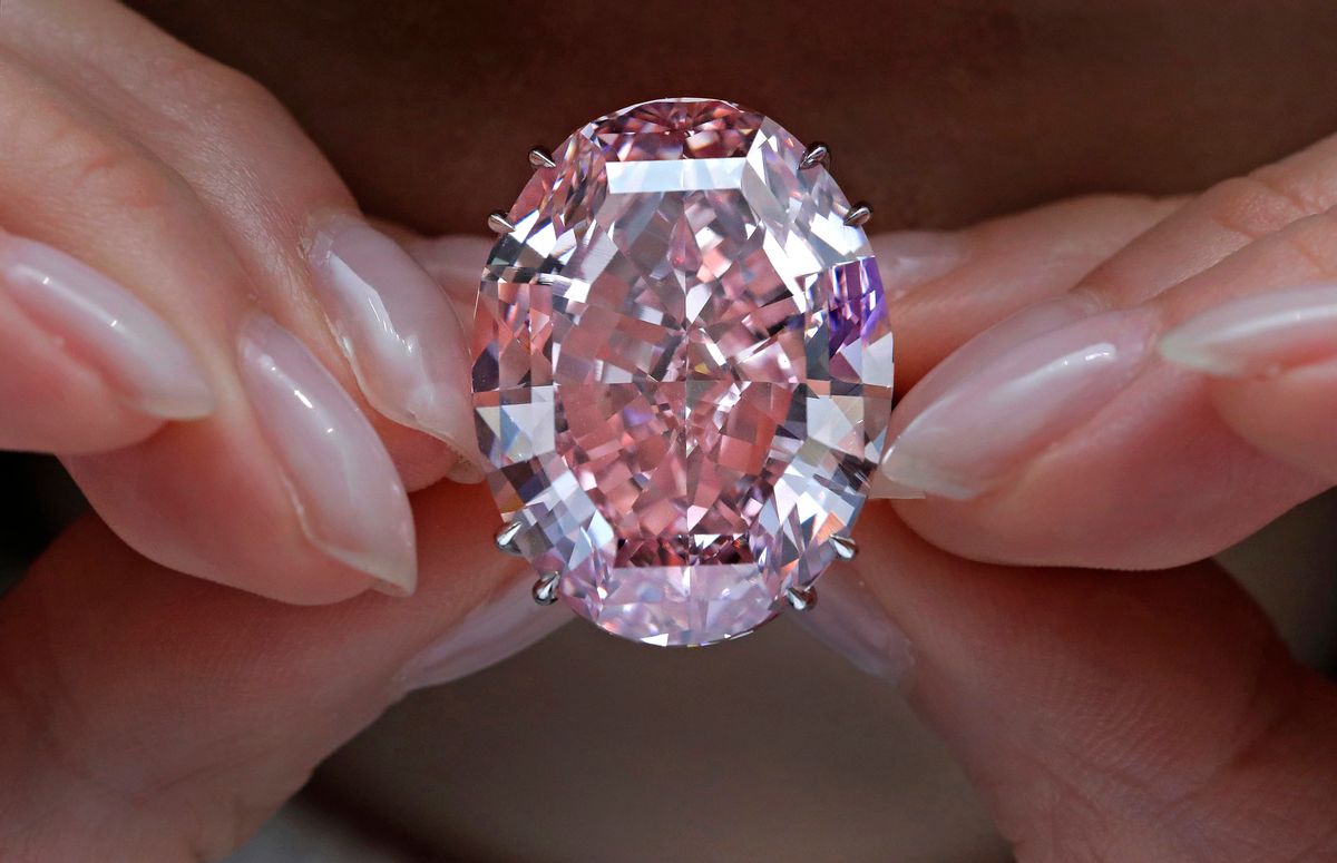 FILE - In this Wednesday, March 29, 2017, file photo, the "Pink Star" diamond, the most valuable cut diamond ever offered at auction, is displayed by a model at a Sotheby's auction room in Hong Kong. The stunning 59.6 carat diamond has sold for HK$553 million or US$71.2 million at a Sotheby's auction in Hong Kong, setting a record for any diamond or jewel. It's Also the highest price for any work ever sold at auction in Asia. (AP Photo/Vincent Yu, File) (AP Photo/Vincent Yu, File)