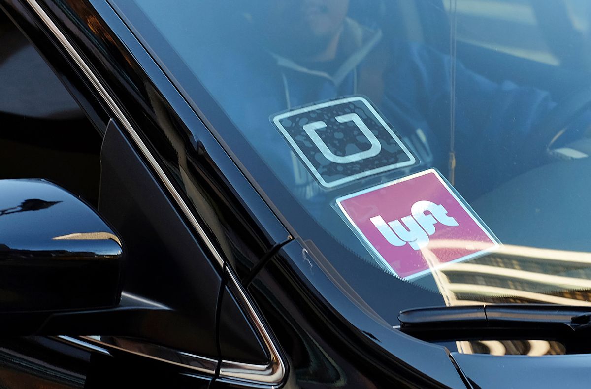 FILE - In this Tuesday, Jan. 12, 2016, file photo, a driver displaying Lyft and Uber stickers on his front windshield drops off a customer in downtown Los Angeles. (AP Photo/Richard Vogel, File)