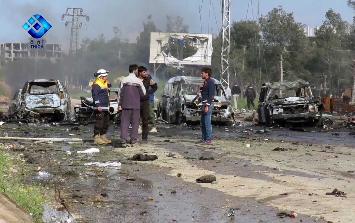 This frame grab from video provided by the Thiqa News Agency, shows rebel gunmen at the site of a blast that damaged several buses and vans at the Rashideen area, a rebel-controlled district outside Aleppo city, Syria, Saturday, April. 15, 2017. Syrian TV said at least 39 people were killed Saturday in an explosion that hit near buses carrying evacuees from two towns besieged by rebels nearby. (Thiqa News via AP) (AP)