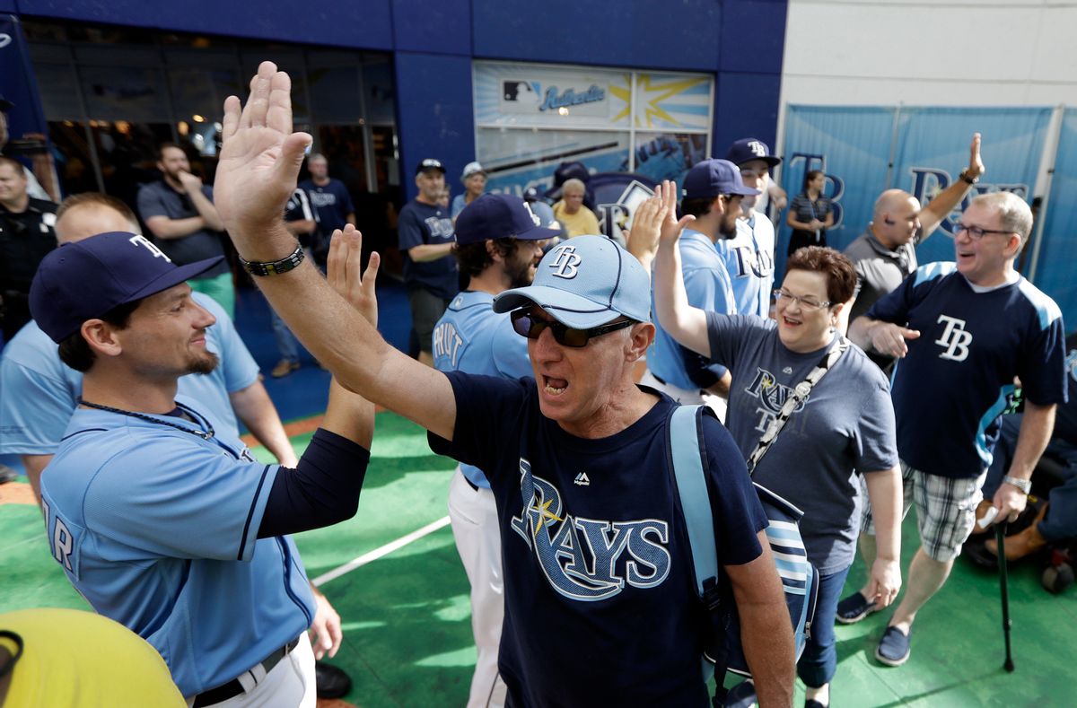 Tampa Bay Rays fans high-five players, including relief pitcher Danny Farquhar, left, as the gates open before an Opening Day baseball game between the Rays and the New York Yankees, Sunday, April 2, 2017, in St. Petersburg, Fla. (AP Photo/Chris O'Meara) (AP)