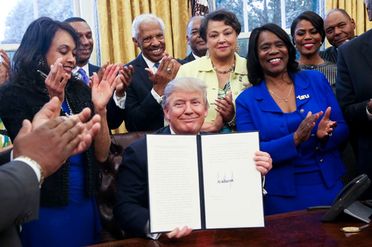 Donald Trump shows the signed executive order supporting black colleges and universities in the Oval Office, February 28, 2017.   (Getty/Aude Guerrucci)