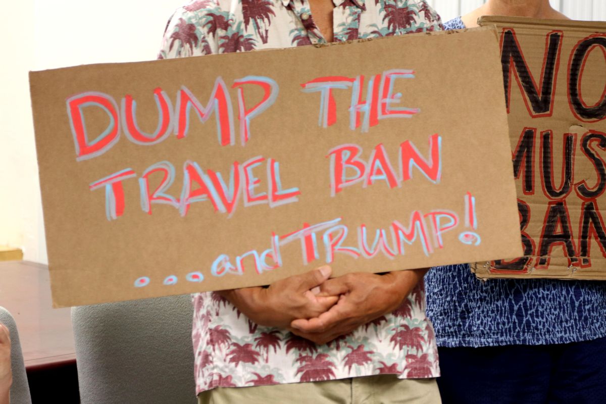FILE- In this June 30, 2017, file photo, critics of President Donald Trump's travel ban hold signs during a news conference with Hawaii Attorney General Douglas Chin in Honolulu. A federal judge in Hawaii on Thursday, July 6, left Trump administration rules in place for a travel ban on citizens from six majority-Muslim countries. U.S. District Court Judge Derrick Watson denied an emergency motion filed by Hawaii asking him to clarify what the U.S. Supreme Court meant by a "bona fide" relationship in its ruling last month. (AP Photo/Caleb Jones, File) (AP Photo/Caleb Jones, File)