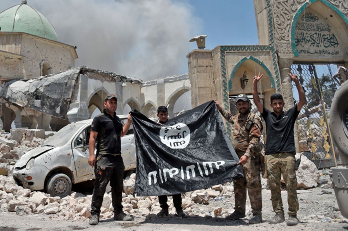 Members of the Iraqi Counter-Terrorism Service (CTS) hold upside-down the flag of the Islamic State (IS) group, in the Old City of Mosul, June 30, 2017.   (Getty/Fadel Senna)
