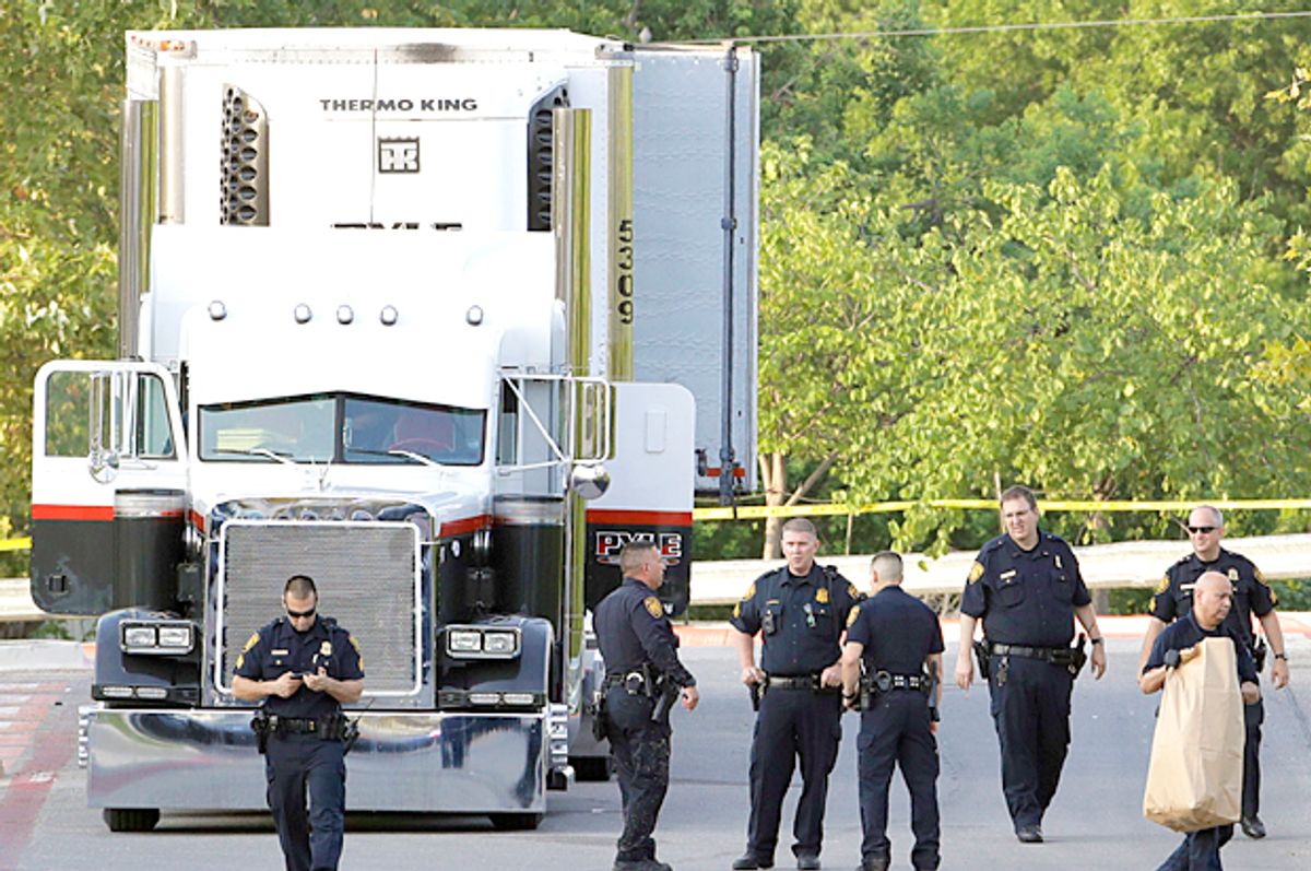 San Antonio police investigate the scene where eight people were found dead in a tractor-trailer loaded with at least 30 others outside a Walmart (AP/Eric Gay)