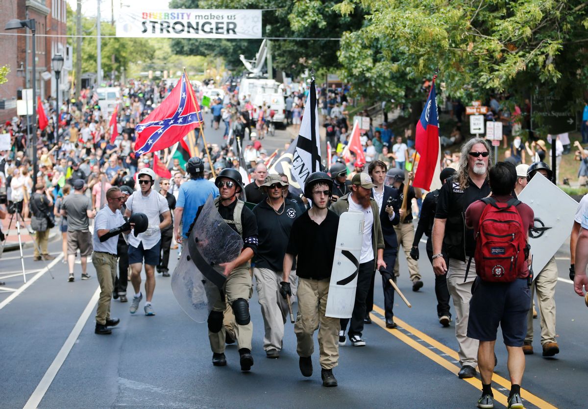 White nationalist demonstrators walk through town after their rally was declared illegal near Lee Park in Charlottesville, Va., Saturday, Aug. 12, 2017.  (AP Photo/Steve Helber)