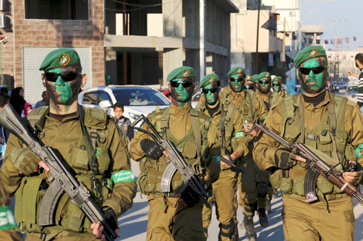 Masked militants from the Izzedine al-Qassam Brigades, a military wing of Hamas, march along the streets of Nusseirat refugee camp, Central Gaza Strip (AP/Adel Hana)