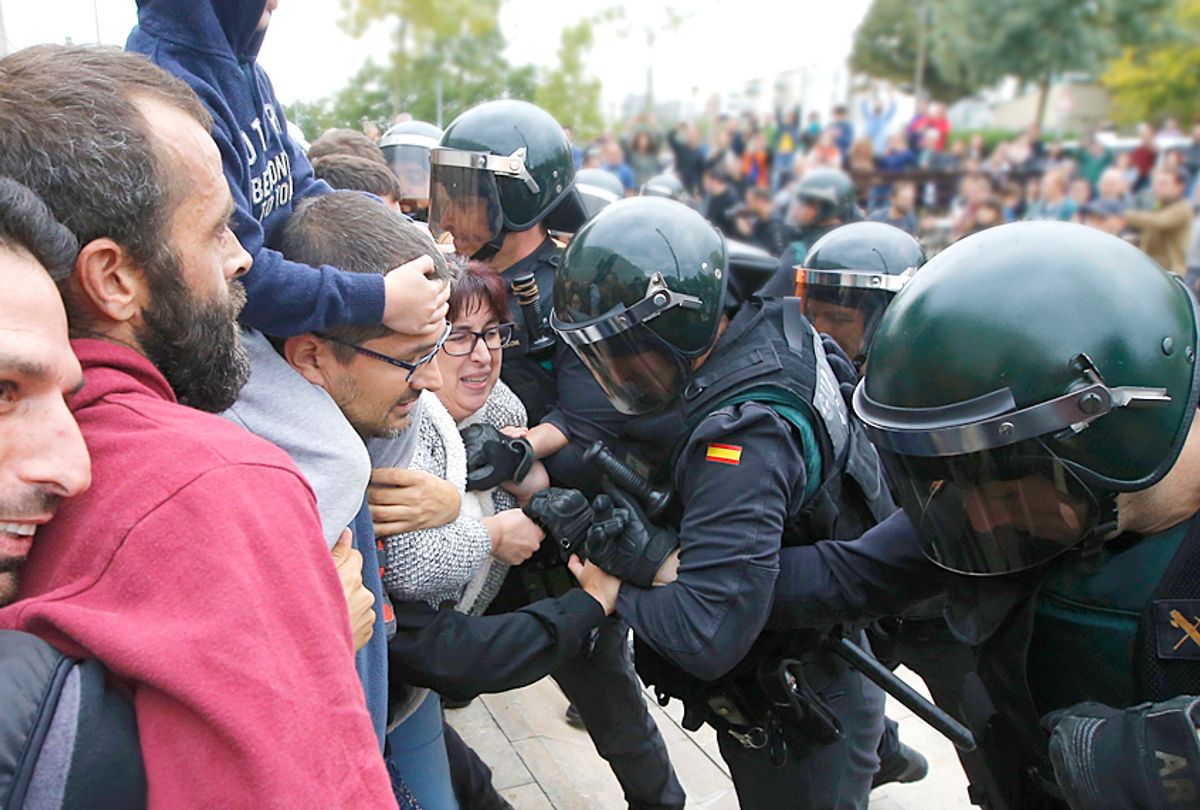 People clash with Spanish Guardia Civil guards outside a polling station. (Getty/Raymond Roig)