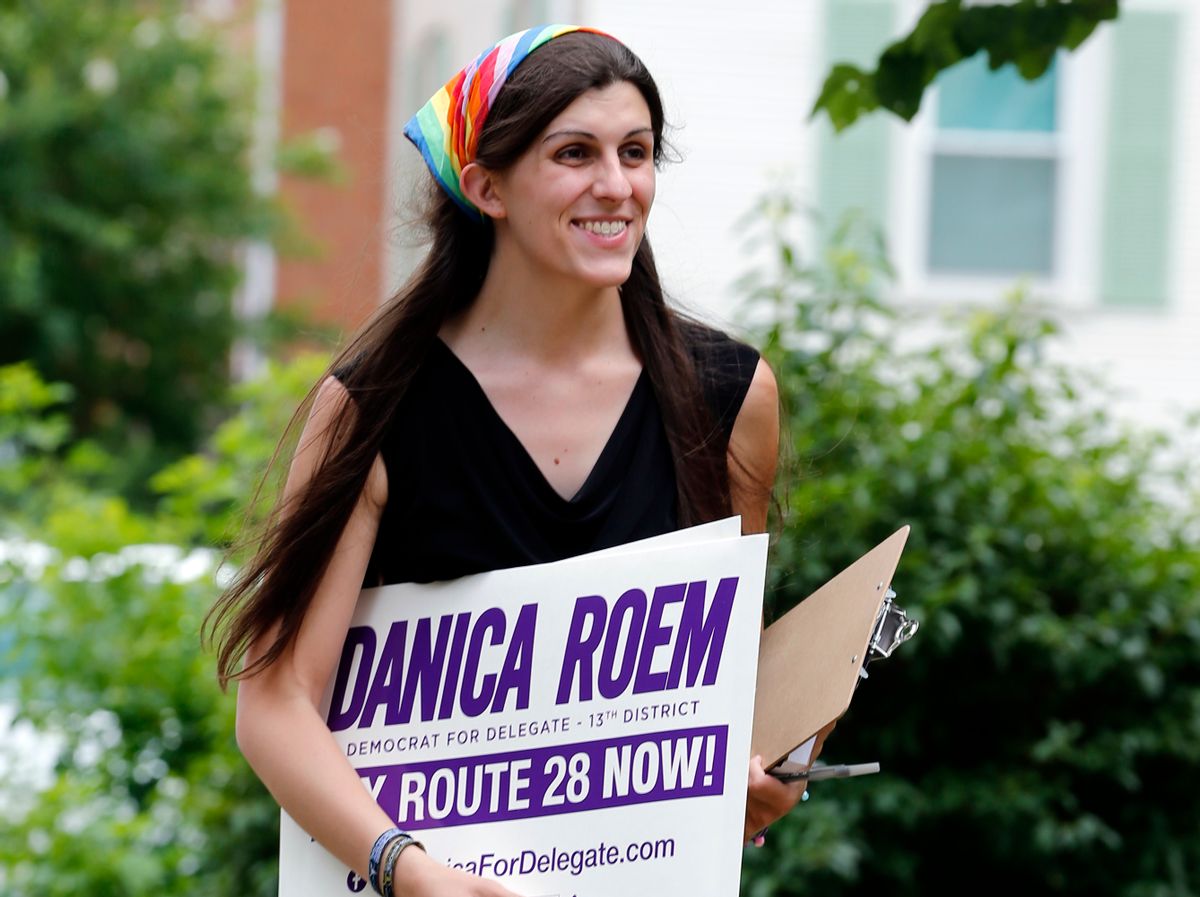 FILE - In this June 21, 2017, file photo, Democratic nominee for the House of Delegates 13th district seat Danica Roem brings campaign signs as she greets voters while canvasing a neighborhood in Manassas, Va. Roem, a former journalist, is challenging longtime incumbent Bob Marshall. If elected, Roem would be the state’s first transgender representative. (AP Photo/Steve Helber, File)