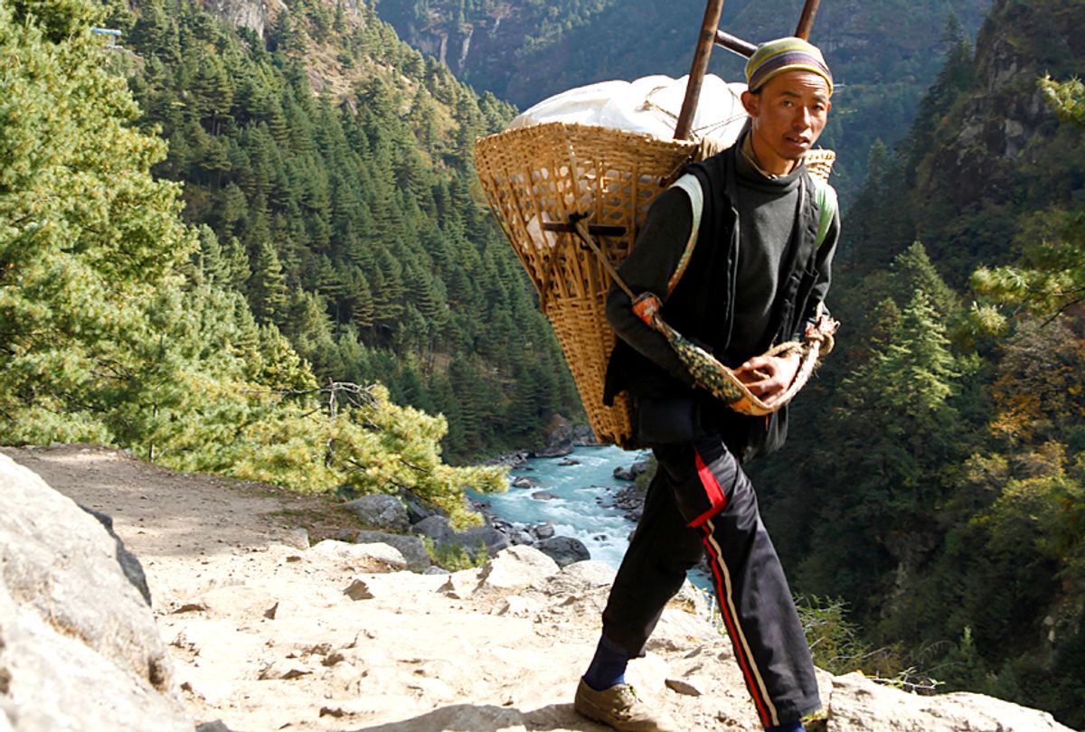A local porter walks towards Lukla to fetch daily supplies. (AP/Tashi Sherpa)