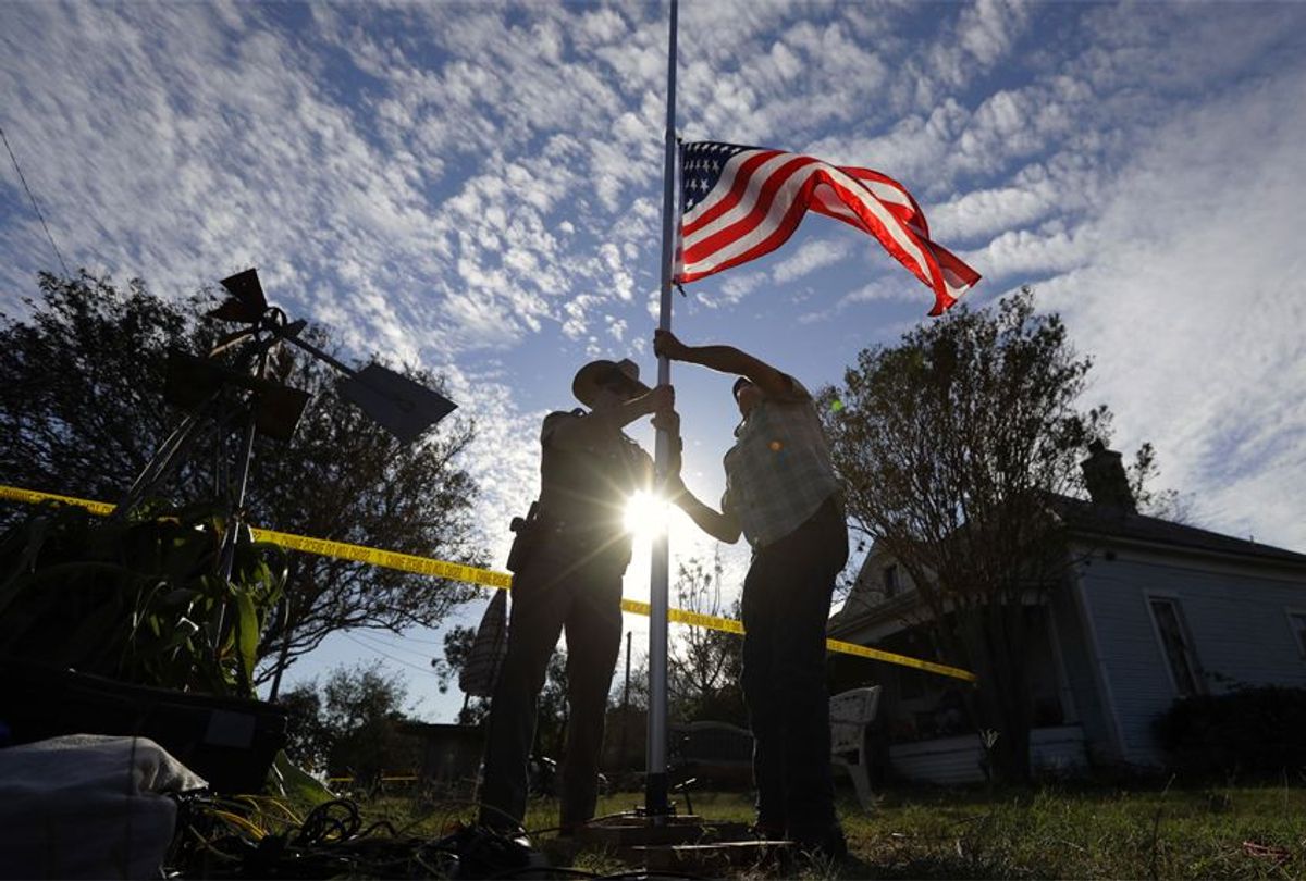 A law enforcement officer helps a man change a flag to half-staff near the scene of the shooting at the First Baptist Church of Sutherland Springs, Nov. 6, 2017. (AP/Eric Gay)