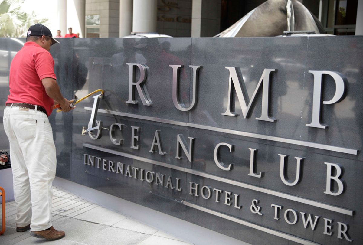 A man removes the word Trump from the marquee outside the Trump Ocean Club International Hotel and Tower in Panama City, March 5, 2018. (AP/Arnulfo Franco)
