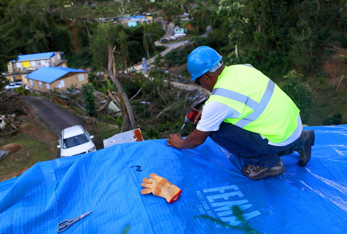 A contractor helps apply a FEMA tarp to a home damaged by Hurricane Maria in Morovis, Puerto Rico. (Getty/Mario Tama)