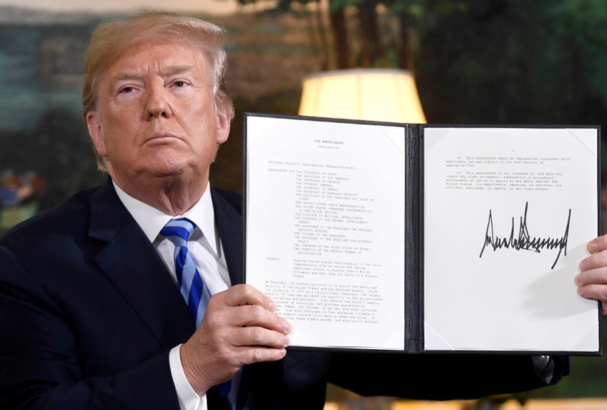 Donald Trump signs a document reinstating sanctions against Iran after announcing the US withdrawal from the Iran Nuclear deal. (Getty/Saul Loeb)
