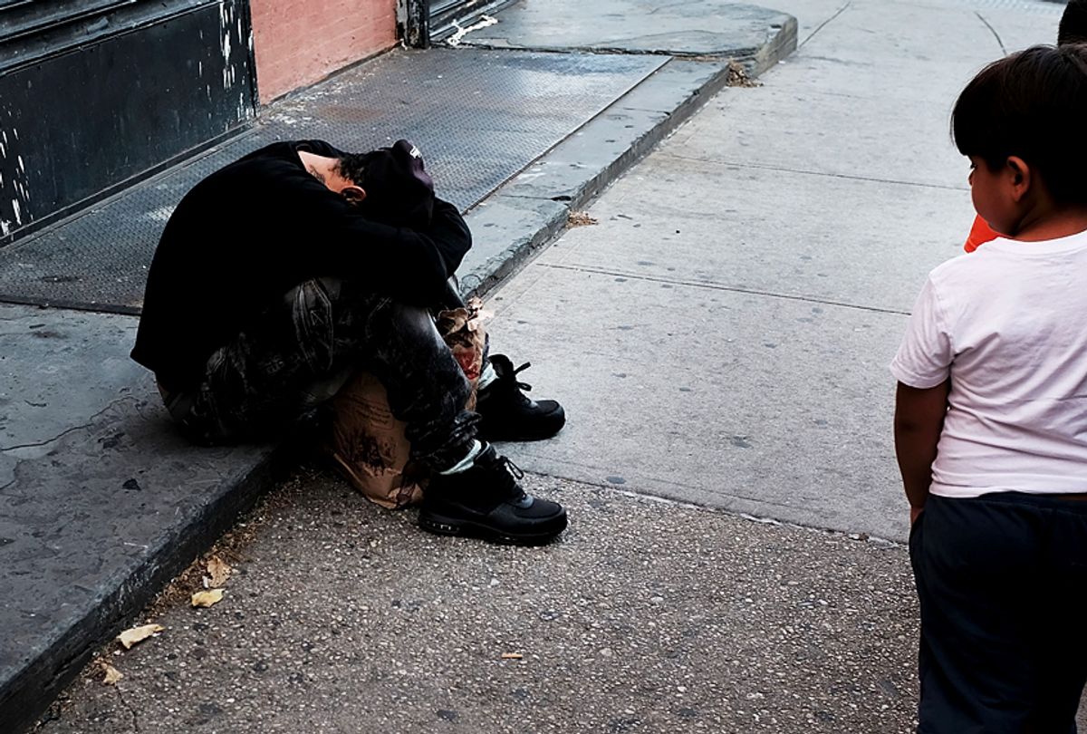 Children walk by drug users passed out along a street in a South Bronx neighborhood which has the highest rate of heroin-involved overdose deaths in the city. (Getty/Spencer Platt)