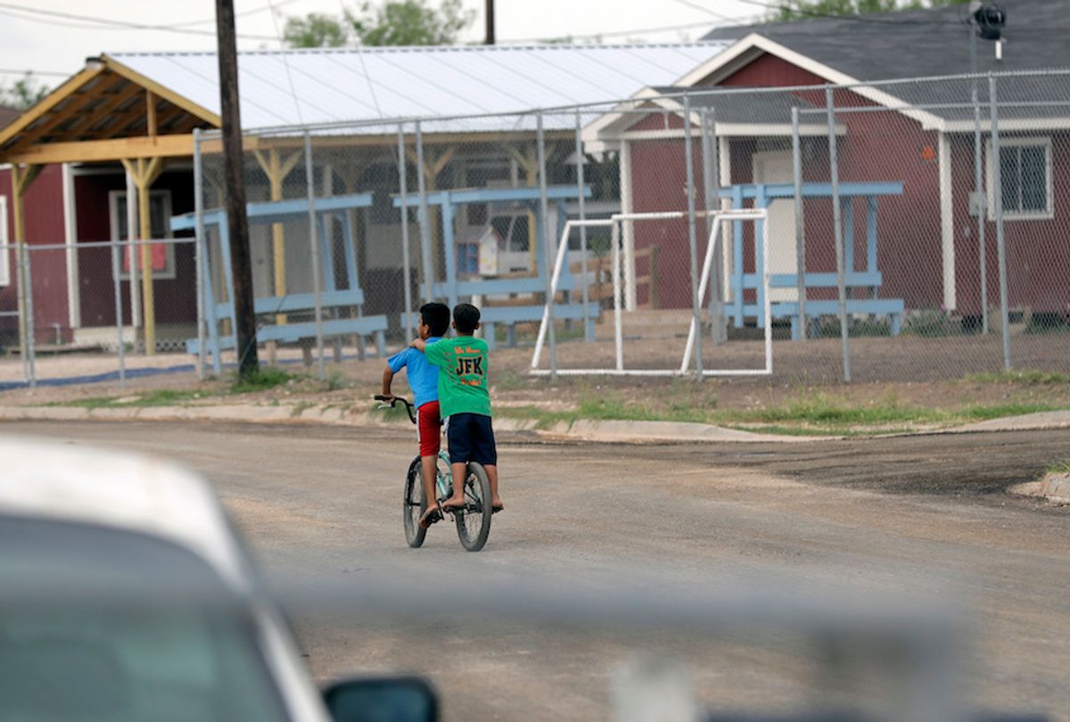 Young boys ride a bike through the Indian Hills East Colonia near Alamo, Texas. (AP/Eric Gay)